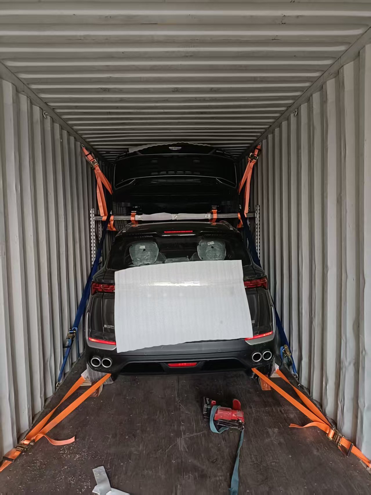 SUV secured on two-tier racking inside a shipping container