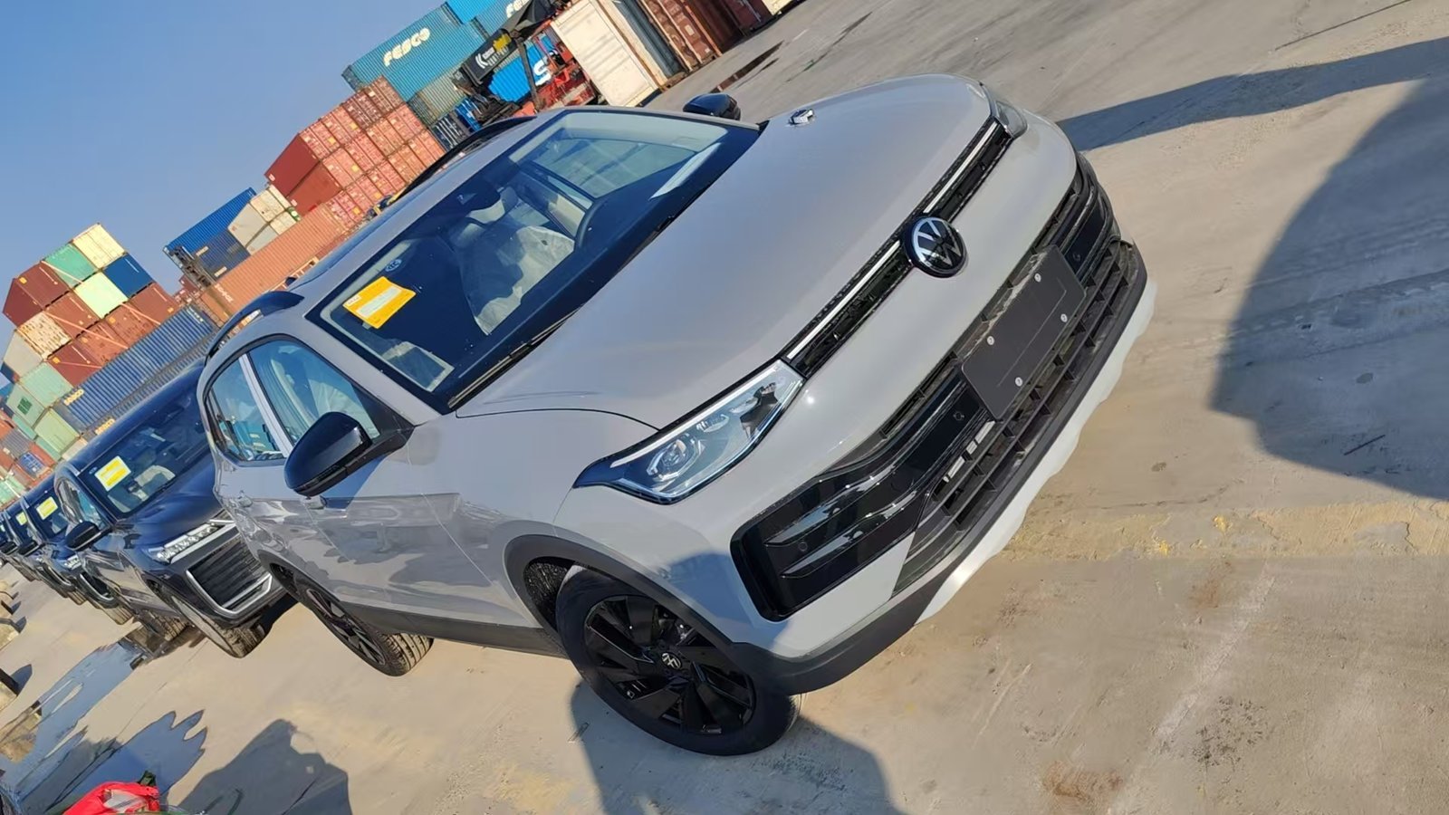 Volkswagen SUVs lined up at a container port